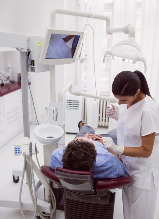 Stomatololog popravlja zube pacijentu