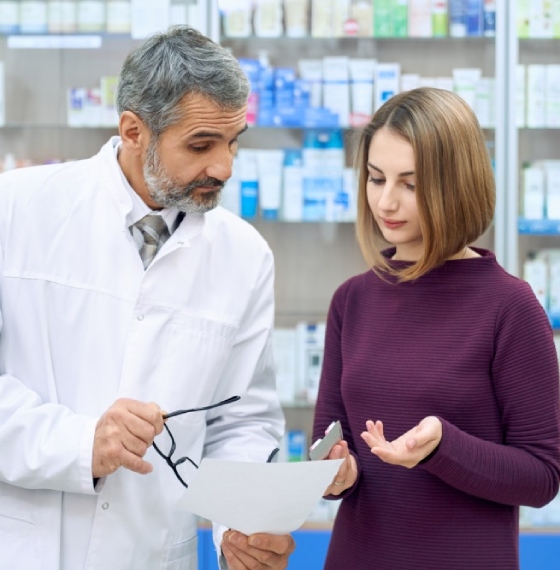 Farmaceut drži Uputstvo za lijek u ruci i pokazuje pacijentu